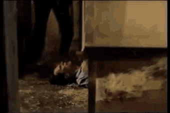 a man is laying on the floor next to a table in a dark room .