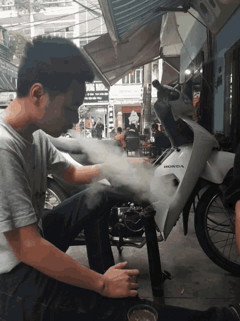 a man is working on a honda motorcycle
