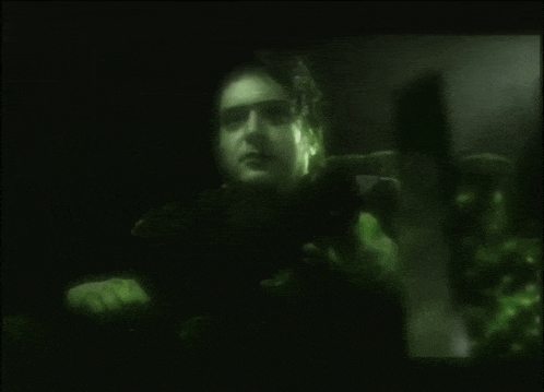 a blurry picture of a man 's face is displayed in a dark room