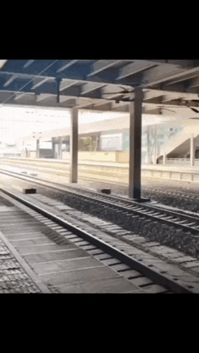 an empty train station with a few tracks and a few pillars