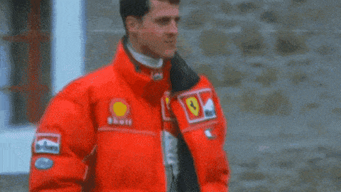 a man wearing a red jacket with a ferrari logo on it