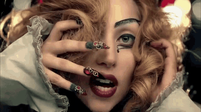 a close up of a woman 's face with long nails