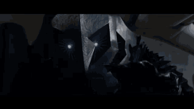 a close up of a person 's face with glowing eyes in the dark .