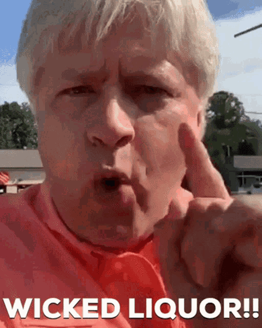 a man in a red shirt says wicked liquor in white letters