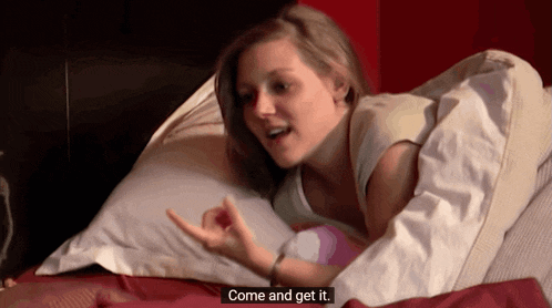a woman laying on a bed with the words come and get it on the bottom