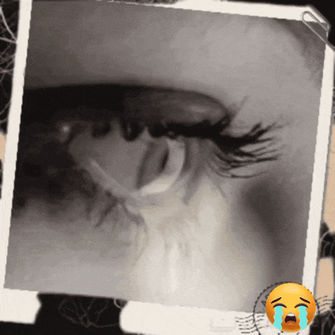 a close up of a woman 's eye with a crying smiley face next to it