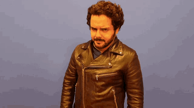 a man with a beard wearing a leather jacket