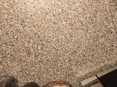 a person standing on a granite floor next to a sign that says ' a ' on it