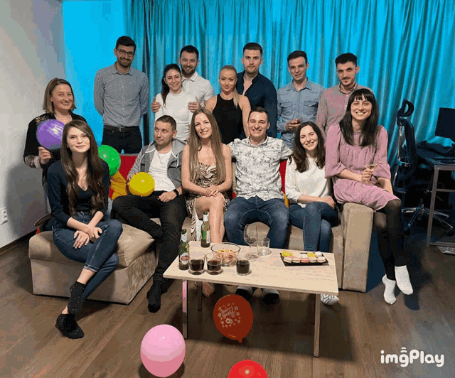 a group of people posing for a picture with balloons in the foreground and the word imgplay in the bottom right corner