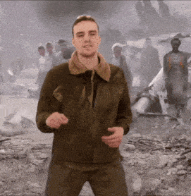 a man in a military jacket is standing in front of a group of people