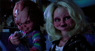 chucky and tiffany from childs play are sitting next to each other in a car .