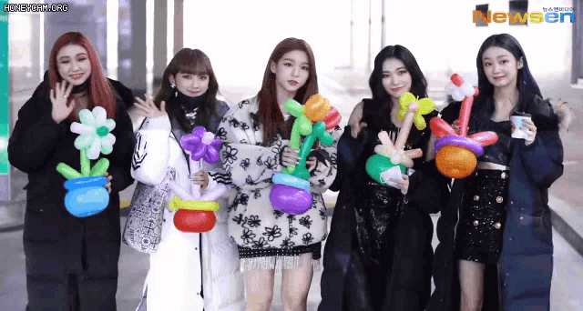 a group of girls are posing for a picture with balloons in their hands
