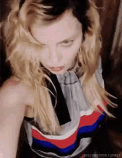 a close up of a woman 's face with her eyes closed wearing a striped top .
