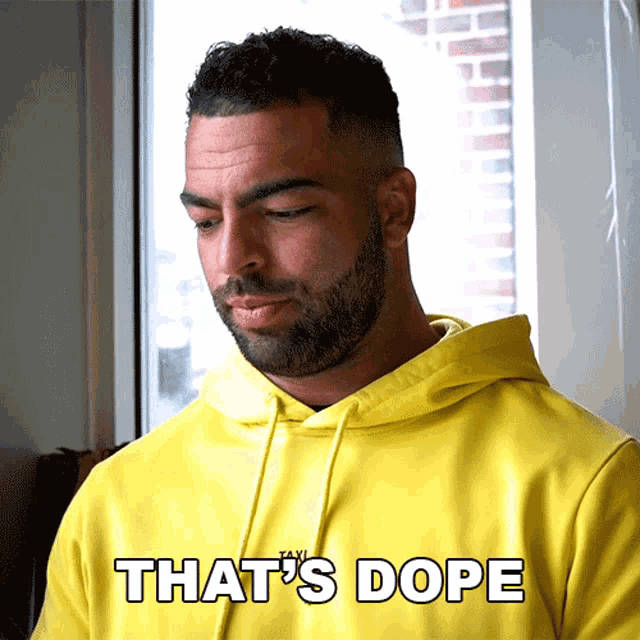 a man wearing a yellow hoodie that says that 's dope on it