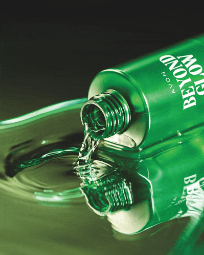 a green bottle of avon beyond cologne is pouring into a glass