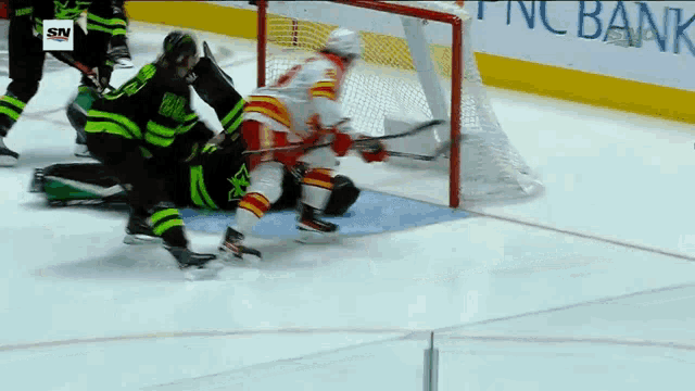 a hockey game is being played in front of a pnc bank banner