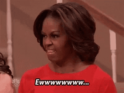 michelle obama is wearing a red shirt and smiling .