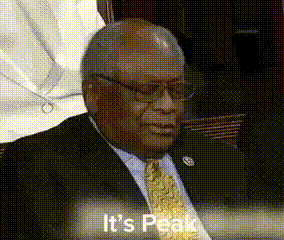 a man in a suit and tie is sitting at a table and says it 's peak .