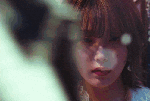 a close up of a woman 's face with a reflection of her face in a mirror