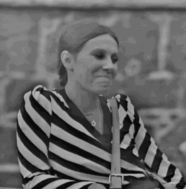 a woman in a striped shirt is smiling in a black and white photo