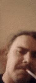 a man is smoking a cigarette in a blurry photo .