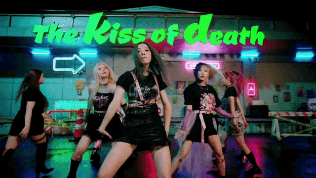 a group of young women are dancing in front of a neon sign that says the kiss of death