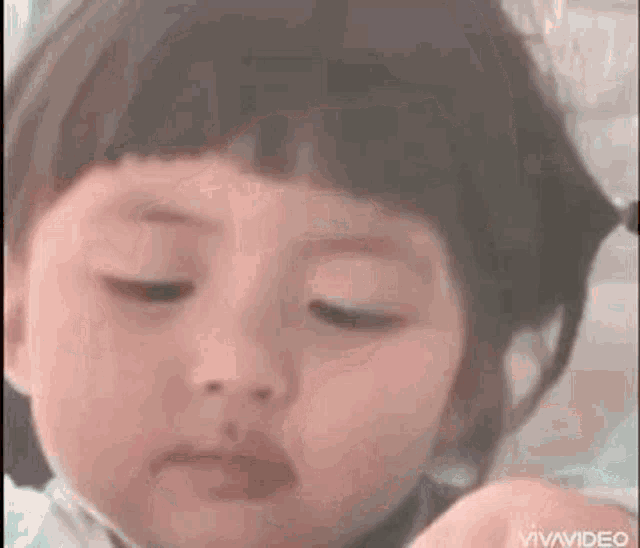 a little girl is making a funny face with her eyes closed and her mouth open .