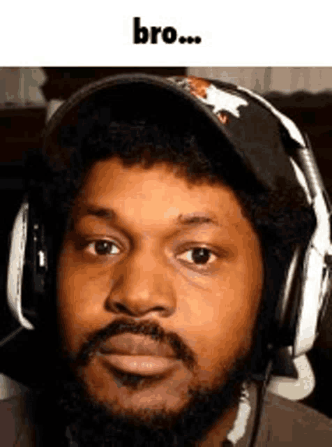 a man with a beard and headphones is wearing a hat .