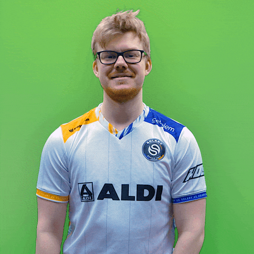 a man wearing glasses and a white shirt with the word aldi on it