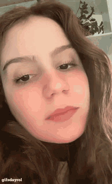 a close up of a woman 's face with the words gifsdayrol on the bottom right