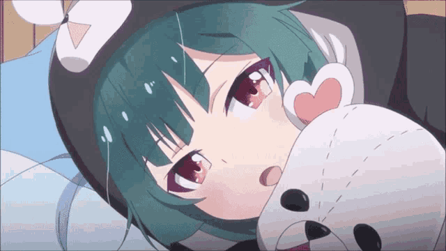 a girl with green hair is laying on a bed with a teddy bear