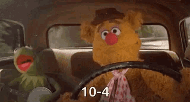 kermit the frog and fozzie bear are driving in a car .
