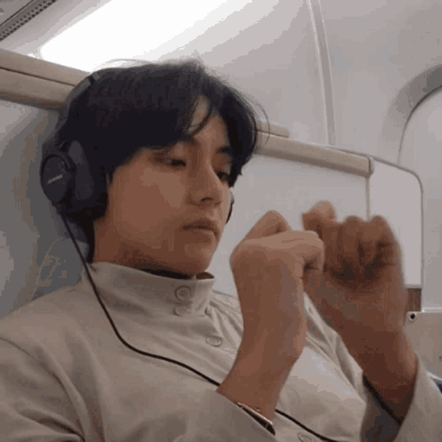 a man wearing headphones is sitting on a plane