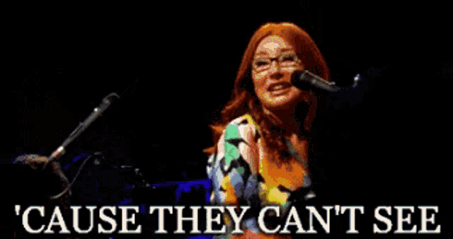 a woman singing into a microphone with the words cause they can 't see below her
