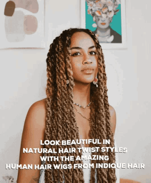 a woman with long twisted hair stands in front of a wall with a picture of a woman on it