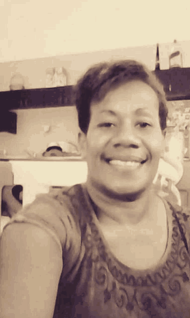 a woman is smiling and taking a selfie in a black and white photo .