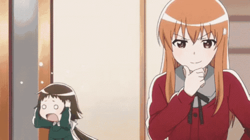 a girl in a red sweater is standing next to a little girl in a green outfit .