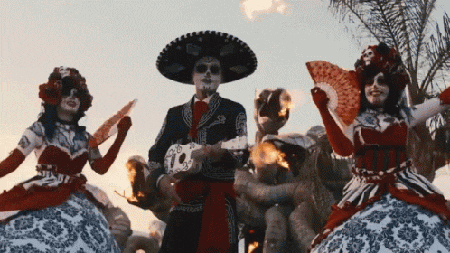 a man in a day of the dead costume is holding a skull mask