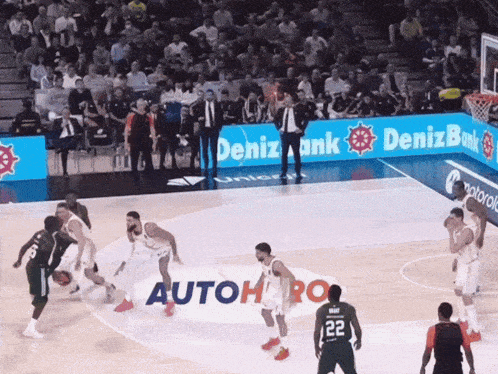 a basketball game is being played in front of a deniz bank ad