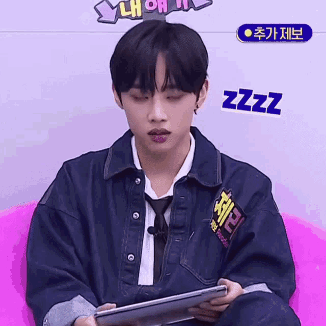 a man wearing a denim jacket and tie is holding a tablet with a sticker that says zzz