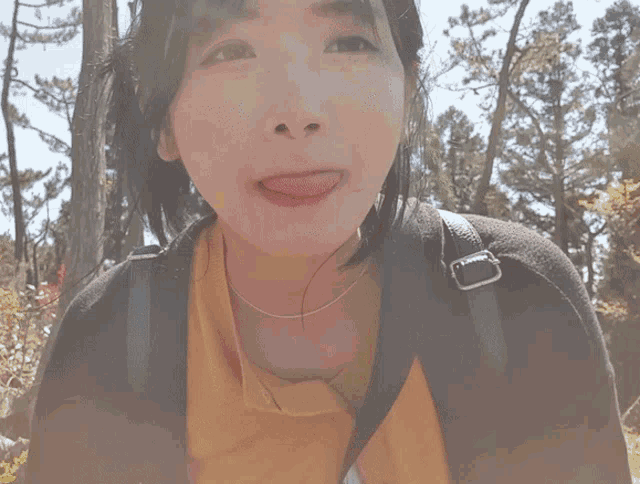 a woman sticking her tongue out while wearing a backpack