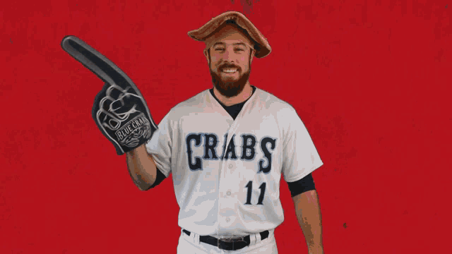 a man in a crabs jersey is holding a foam finger