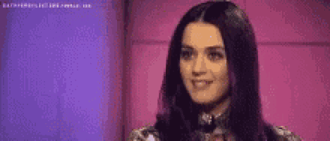 a woman with long black hair is smiling and looking up at the camera .