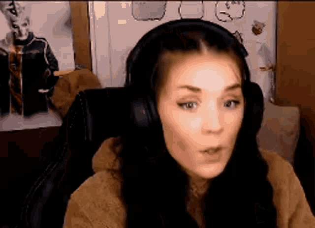a woman wearing headphones is sitting in a chair and looking at the camera .