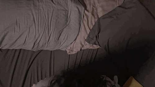 a woman is laying on a bed with her head on a pillow