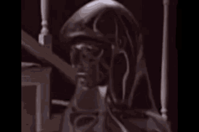 a statue of a person with a hood on sitting on a staircase