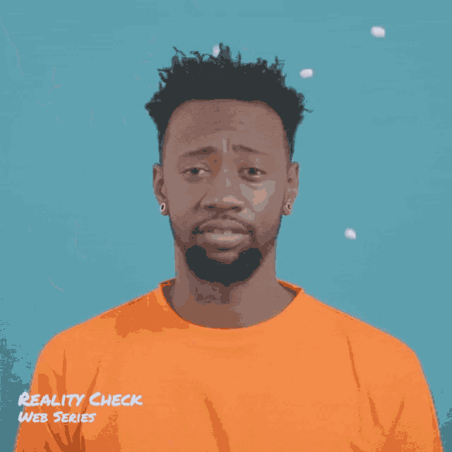 a man in an orange shirt with reality check web series on the bottom