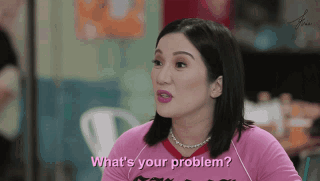 a woman in a pink shirt is asking what 's your problem