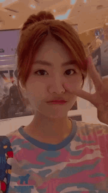 a woman making a peace sign with her finger