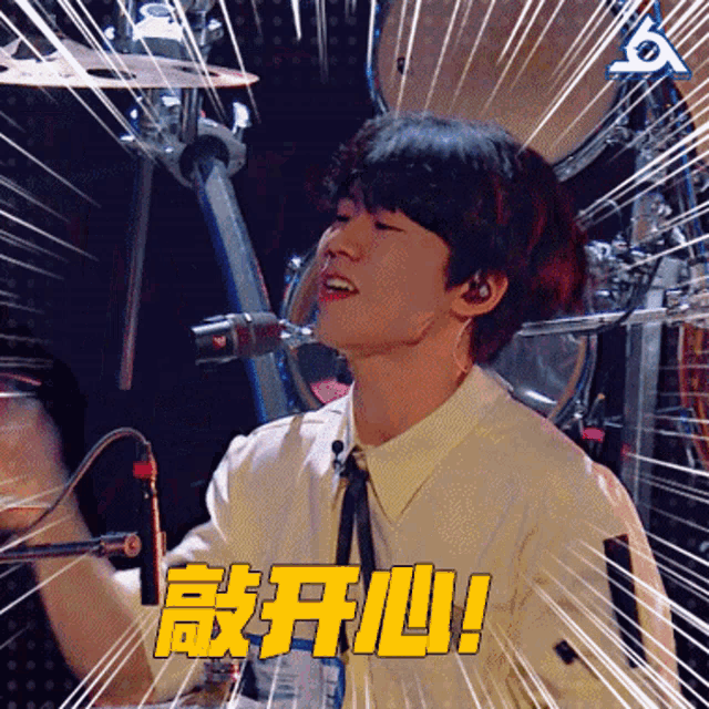 a young man singing into a microphone with chinese writing on the bottom